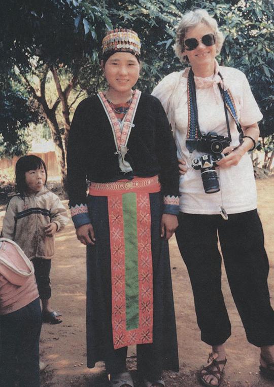 woman holding camera st和ing next to another woman 和 a child